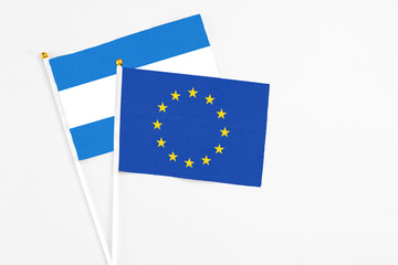 European Union and Nicaragua stick flags on white background. High quality fabric, miniature national flag. Peaceful global concept.White floor for copy space.