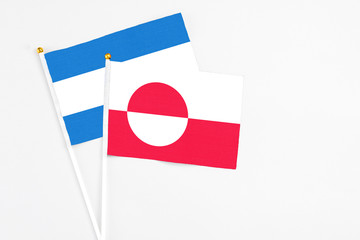 Greenland and Nicaragua stick flags on white background. High quality fabric, miniature national flag. Peaceful global concept.White floor for copy space.