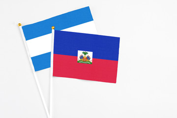 Haiti and Nicaragua stick flags on white background. High quality fabric, miniature national flag. Peaceful global concept.White floor for copy space.