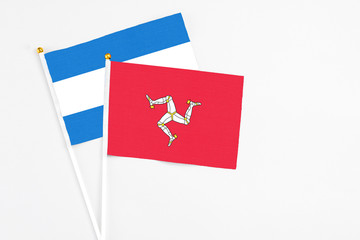 Isle Of Man and Nicaragua stick flags on white background. High quality fabric, miniature national flag. Peaceful global concept.White floor for copy space.