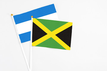 Jamaica and Nicaragua stick flags on white background. High quality fabric, miniature national flag. Peaceful global concept.White floor for copy space.