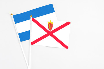 Jersey and Nicaragua stick flags on white background. High quality fabric, miniature national flag. Peaceful global concept.White floor for copy space.