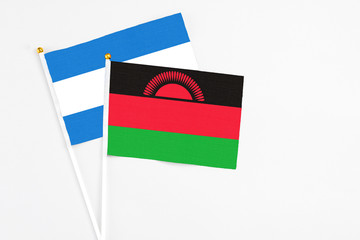 Malawi and Nicaragua stick flags on white background. High quality fabric, miniature national flag. Peaceful global concept.White floor for copy space.