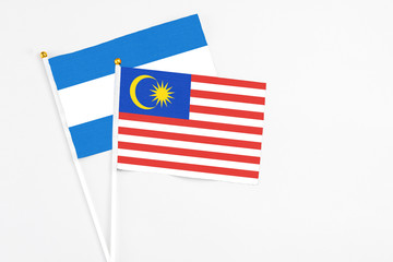 Malaysia and Nicaragua stick flags on white background. High quality fabric, miniature national flag. Peaceful global concept.White floor for copy space.
