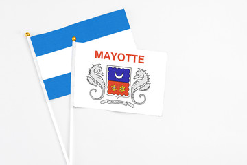 Mayotte and Nicaragua stick flags on white background. High quality fabric, miniature national flag. Peaceful global concept.White floor for copy space.