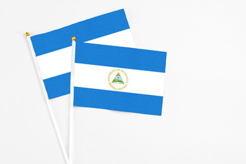 Nicaragua and Nicaragua stick flags on white background. High quality fabric, miniature national flag. Peaceful global concept.White floor for copy space.