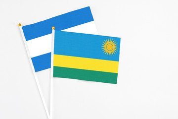 Rwanda and Nicaragua stick flags on white background. High quality fabric, miniature national flag. Peaceful global concept.White floor for copy space.