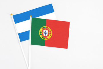 Portugal and Nicaragua stick flags on white background. High quality fabric, miniature national flag. Peaceful global concept.White floor for copy space.