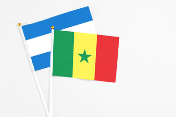 Senegal and Nicaragua stick flags on white background. High quality fabric, miniature national flag. Peaceful global concept.White floor for copy space.