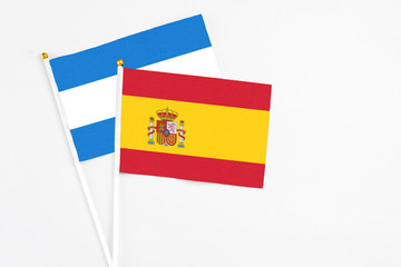 Spain and Nicaragua stick flags on white background. High quality fabric, miniature national flag. Peaceful global concept.White floor for copy space.