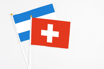 Switzerland and Nicaragua stick flags on white background. High quality fabric, miniature national flag. Peaceful global concept.White floor for copy space.