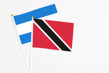 Trinidad And Tobago and Nicaragua stick flags on white background. High quality fabric, miniature national flag. Peaceful global concept.White floor for copy space.