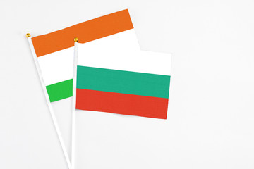 Bulgaria and Niger stick flags on white background. High quality fabric, miniature national flag. Peaceful global concept.White floor for copy space.