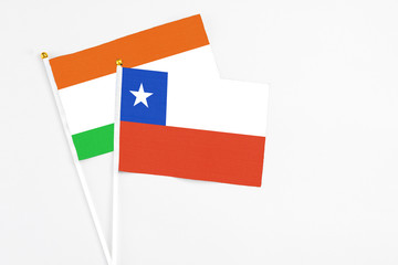 Chile and Niger stick flags on white background. High quality fabric, miniature national flag. Peaceful global concept.White floor for copy space.