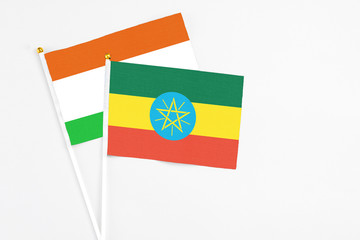 Ethiopia and Niger stick flags on white background. High quality fabric, miniature national flag. Peaceful global concept.White floor for copy space.