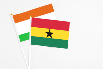 Ghana and Niger stick flags on white background. High quality fabric, miniature national flag. Peaceful global concept.White floor for copy space.