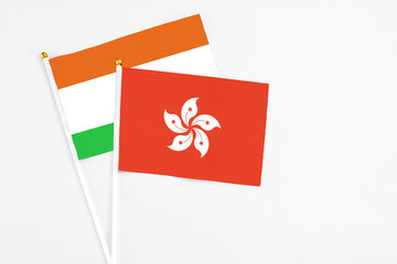 Hong Kong and Niger stick flags on white background. High quality fabric, miniature national flag. Peaceful global concept.White floor for copy space.