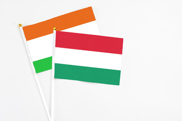 Hungary and Niger stick flags on white background. High quality fabric, miniature national flag. Peaceful global concept.White floor for copy space.