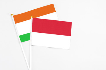 Indonesia and Niger stick flags on white background. High quality fabric, miniature national flag. Peaceful global concept.White floor for copy space.