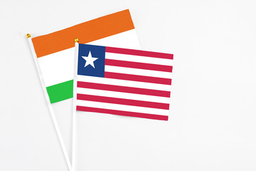 Liberia and Niger stick flags on white background. High quality fabric, miniature national flag. Peaceful global concept.White floor for copy space.
