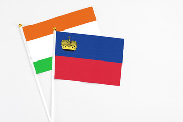 Liechtenstein and Niger stick flags on white background. High quality fabric, miniature national flag. Peaceful global concept.White floor for copy space.