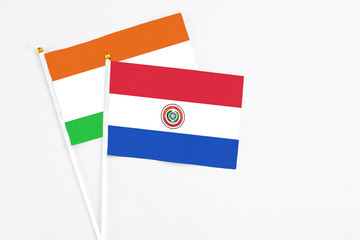 Paraguay and Niger stick flags on white background. High quality fabric, miniature national flag. Peaceful global concept.White floor for copy space.