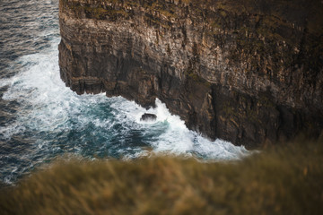 Sea waves crashing against rocks in Cliffs of Moher, Ireland