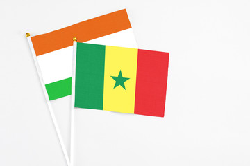 Senegal and Niger stick flags on white background. High quality fabric, miniature national flag. Peaceful global concept.White floor for copy space.
