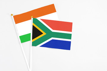 South Africa and Niger stick flags on white background. High quality fabric, miniature national flag. Peaceful global concept.White floor for copy space.