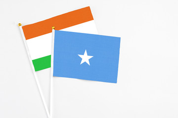 Somalia and Niger stick flags on white background. High quality fabric, miniature national flag. Peaceful global concept.White floor for copy space.