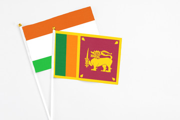 Sri Lanka and Niger stick flags on white background. High quality fabric, miniature national flag. Peaceful global concept.White floor for copy space.