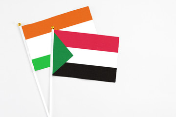 Sudan and Niger stick flags on white background. High quality fabric, miniature national flag. Peaceful global concept.White floor for copy space.