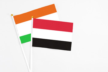 Yemen and Niger stick flags on white background. High quality fabric, miniature national flag. Peaceful global concept.White floor for copy space.