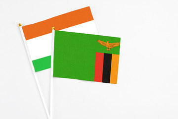 Zambia and Niger stick flags on white background. High quality fabric, miniature national flag. Peaceful global concept.White floor for copy space.