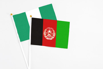 Afghanistan and Nigeria stick flags on white background. High quality fabric, miniature national flag. Peaceful global concept.White floor for copy space.