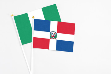 Dominican Republic and Nigeria stick flags on white background. High quality fabric, miniature national flag. Peaceful global concept.White floor for copy space.
