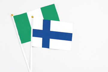 Finland and Nigeria stick flags on white background. High quality fabric, miniature national flag....