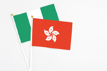 Hong Kong and Nigeria stick flags on white background. High quality fabric, miniature national flag. Peaceful global concept.White floor for copy space.