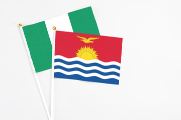 Kiribati and Nigeria stick flags on white background. High quality fabric, miniature national flag. Peaceful global concept.White floor for copy space.