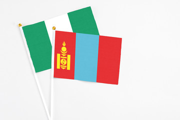 Mongolia and Nigeria stick flags on white background. High quality fabric, miniature national flag. Peaceful global concept.White floor for copy space.