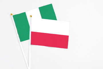 Poland and Nigeria stick flags on white background. High quality fabric, miniature national flag. Peaceful global concept.White floor for copy space.