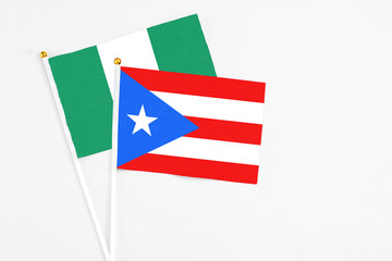 Puerto Rico and Nigeria stick flags on white background. High quality fabric, miniature national flag. Peaceful global concept.White floor for copy space.