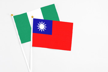 Taiwan and Nigeria stick flags on white background. High quality fabric, miniature national flag. Peaceful global concept.White floor for copy space.