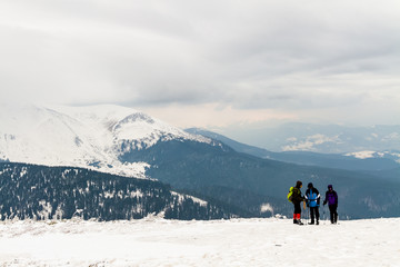 Fototapeta na wymiar high in the mountains is a group of three people, in the background is Hoverla Mountain, Carpathians, Ukraine.