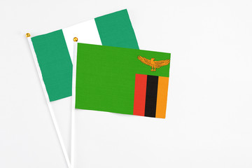 Zambia and Nigeria stick flags on white background. High quality fabric, miniature national flag. Peaceful global concept.White floor for copy space.