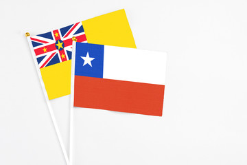 Chile and Niue stick flags on white background. High quality fabric, miniature national flag. Peaceful global concept.White floor for copy space.