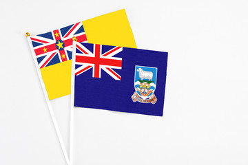 Falkland Islands and Niue stick flags on white background. High quality fabric, miniature national...