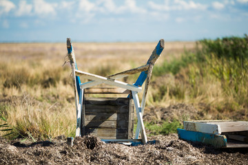 Old inverted wooden chair on the grass. Abandoned terrain