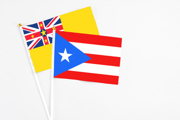 Puerto Rico and Niue stick flags on white background. High quality fabric, miniature national flag. Peaceful global concept.White floor for copy space.