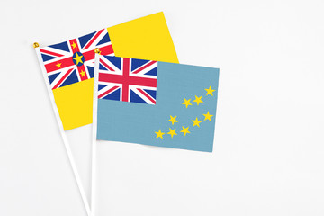 Tuvalu and Niue stick flags on white background. High quality fabric, miniature national flag. Peaceful global concept.White floor for copy space.